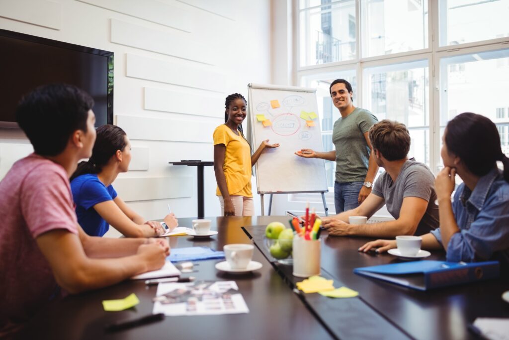 Discussion entre collègues devant un tableau blanc