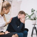 Une femme apporte son soutien à un collègue en difficulté qui est sur le point de pleurer