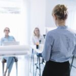 businesswoman-giving-presentation-meeting-scaled