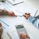 institut-4.10-creances-assurance-maladie calculatrice deux personnes avec dossiers au travail